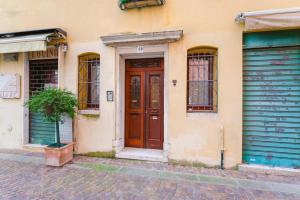 un bâtiment avec deux portes et une plante en pot dans une rue dans l'établissement Caneve Home - 15 min from Venice & Wi-Fi, à Venise
