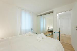 une chambre avec un lit blanc et un miroir dans l'établissement Caneve Home - 15 min from Venice & Wi-Fi, à Venise