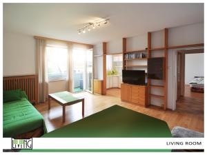 クラーゲンフルトにあるACO Living - Appartement Chill Outのリビングルーム(緑のソファ、テレビ付)