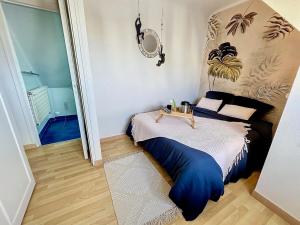 a bedroom with a bed with a large blue cover at Escale en bord de mer T3 au coeur de Saint-Quay in Saint-Quay-Portrieux +8 photos
