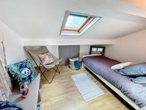 a room with a bed and a couch and a window at Escale en bord de mer T3 au coeur de Saint-Quay in Saint-Quay-Portrieux