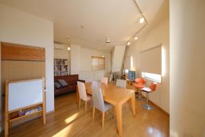 une salle à manger avec une table, des chaises et un canapé dans l'établissement Casa Hiro, à Osaka