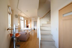 un escalier menant à un salon et une salle à manger dans l'établissement Casa Hiro, à Osaka