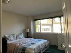 a bedroom with a bed and a large window at greenview mck sunny room in Calgary
