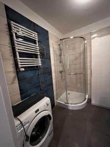 eine Waschmaschine in einem Badezimmer mit Dusche in der Unterkunft Studio Mewa in Świnoujście