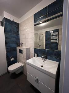 ein Badezimmer mit einem weißen Waschbecken und einer Toilette in der Unterkunft Studio Mewa in Świnoujście