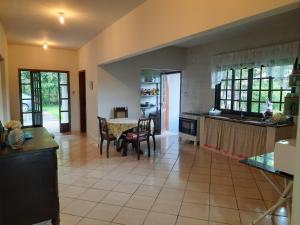 une cuisine et une salle à manger avec une table et des chaises dans l'établissement Rancho São Miguel Arcanjo, à Caçapava