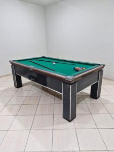 une table de billard posée sur un plancher dans l'établissement Rancho São Miguel Arcanjo, à Caçapava