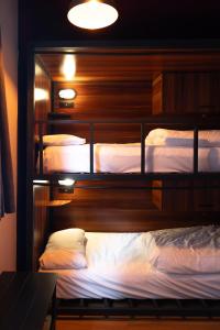 a bedroom with two bunk beds with white sheets at Malacuna Liverpool in Liverpool +50 photos