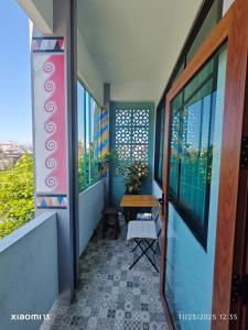 balcón con mesa y algunas ventanas en TarTar & Nay Hostel, en Chiang Mai