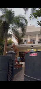 una palmera frente a un edificio con un cartel en Seawind, en Kannur