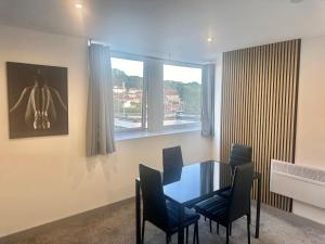 伊登2BR Furnished l Wi-Fi l Parking in Leeds的一间有桌子、椅子和窗户的餐厅