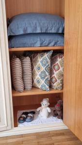 a shelf with pillows and a stuffed animal in a cabinet at Assisi - Appartamento Maristella in Santa Maria degli Angeli +2 photos