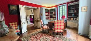 a room with a table and chairs and bookshelves at Demeure 13 Personnes Au Centre Ville De Ruffec in Ruffec +40 photos