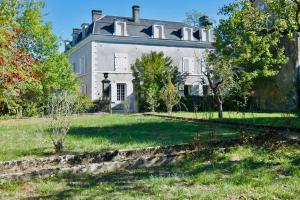 an old house with a grassy yard in front of it at Demeure 13 personnes au Centre ville de Ruffec in Ruffec