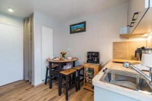 a kitchen with a sink and a table in a room at Havre de paix proche de la mer, pointe de Pors Pin in Plouézec
