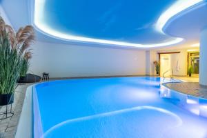 a large swimming pool with a blue ceiling at SEETELHOTEL Ostseehotel das Entdeckerhotel an der Ostsee und der perfekte Startpunkt für Ihre Inselabenteuer in Ahlbeck