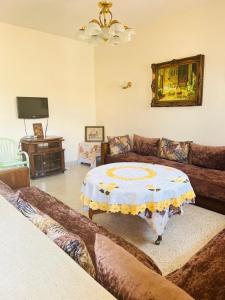 ein Wohnzimmer mit Sofa und Tisch in der Unterkunft Lala Khnata in Temara