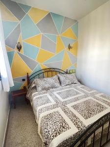 ein Schlafzimmer mit einem Bett und einer geometrischen Wand in der Unterkunft Lala Khnata in Temara