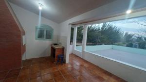 a bathroom with a tub and a large window at Vida Mansa Apartamentos in Capão Novo