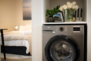 克尼斯纳212 Seahorse - Spacious 2 Bedroom Premium Unit的一间带洗衣机和床的房间