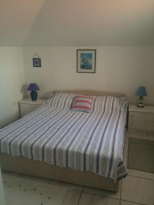 a bedroom with a large bed with a striped blanket at Apartment Gigi in Jadranovo