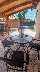 a glass table and chairs on a patio at Artin House Mendoza in Ciudad Lujan de Cuyo