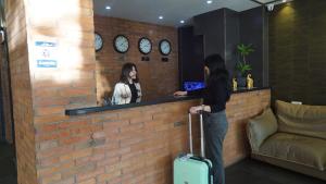 a woman standing at a bar with her luggage at TM Apart Hotel in Tbilisi City +59 photos