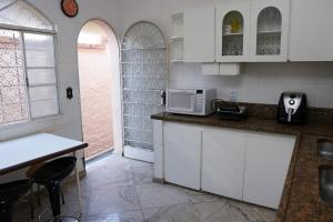 a kitchen with a counter top with a microwave at Casarão José Morada in Belo Horizonte