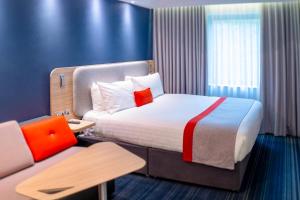 a hotel room with a bed and a couch at Holiday Inn Express St. Albans - M25, Jct.22 in Saint Albans +66 photos