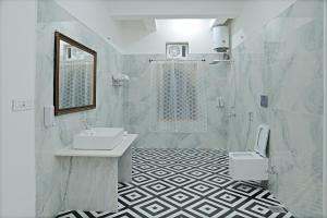 a white bathroom with a sink and a toilet at Govind Garh Nathdwara in Namano