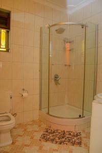 a bathroom with a shower and a toilet at Calm Suites Kampala in Kampala +46 photos