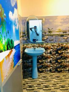 a bathroom with a sink and a mirror with a painting at Umami Japanese House Tangalle in Tangalle +3 photos