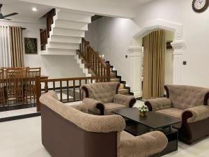ein Wohnzimmer mit Stühlen, einem Tisch und Treppen in der Unterkunft Delight Villa - Ahangama in Ahangama + 17 Fotos