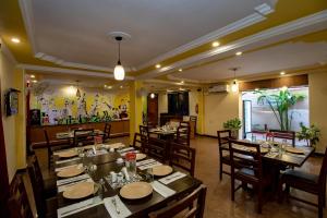 ein Speisesaal mit Tischen und Stühlen in einem Restaurant in der Unterkunft Hotel Orient Royal in Calangute