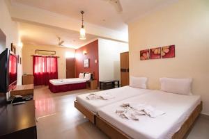 ein Schlafzimmer mit einem großen Bett und einem Fernseher in der Unterkunft Hotel Orient Royal in Calangute
