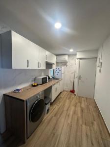 una cucina con armadietti bianchi e lavatrice di Ribera y Gastronomía ad Aranda de Duero Altre 9 foto