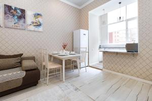 ein Wohnzimmer mit Tisch und Küche in der Unterkunft Трех комнатные апартаменты в новом доме рядом с Батырмол in Pawlodar