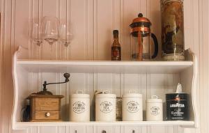 a cupboard with wine glasses and wine bottles and a shelf with cups at Stunning Home In Ljørdalen With Sauna in Ljørdalen