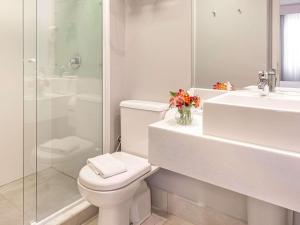 een badkamer met een toilet, een wastafel en een douche bij Mercure Sao Paulo Vila Olimpia in Sao Paulo