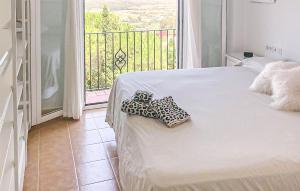 a bed with two pillows on it in a room with a balcony at 2 Bedroom Awesome Apartment In Facinas - Tarifa in Facinas
