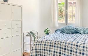 a bedroom with a bed with a checkered blanket at 2 Bedroom Awesome Apartment In Facinas - Tarifa in Facinas +4 photos