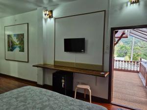a bedroom with a flat screen tv on the wall at Nur Nur Residence and villa in Surin Beach