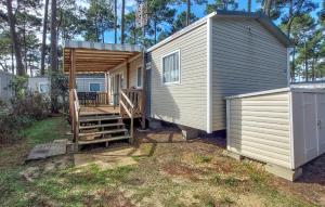 a tiny house with a porch and a deck at Nice Stacaravan In Saint-Julien-En-Born in Saint-Julien-en-Born +7 photos