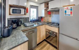a small kitchen with a refrigerator and a sink at Nice Stacaravan In Saint-Julien-En-Born in Saint-Julien-en-Born