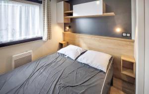 a small bedroom with a bed and a window at Nice Stacaravan In Saint-Julien-En-Born in Saint-Julien-en-Born