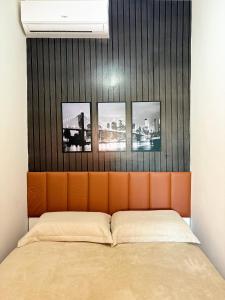 ein Bett mit vier Bildern über der Wand in der Unterkunft Apartamento 1/4 Ambiente inteiro in Lauro de Freitas