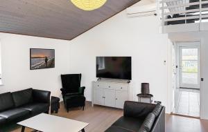 a living room with a couch and a tv at Beautiful Home In Rødby With Wifi in Tjørnebjerg