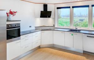 a kitchen with white cabinets and a large window at Beautiful Home In Rødby With Wifi in Tjørnebjerg
