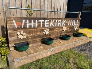 una panca di legno con quattro vasi nell'erba di Landal Whitekirk Hill a North Berwick